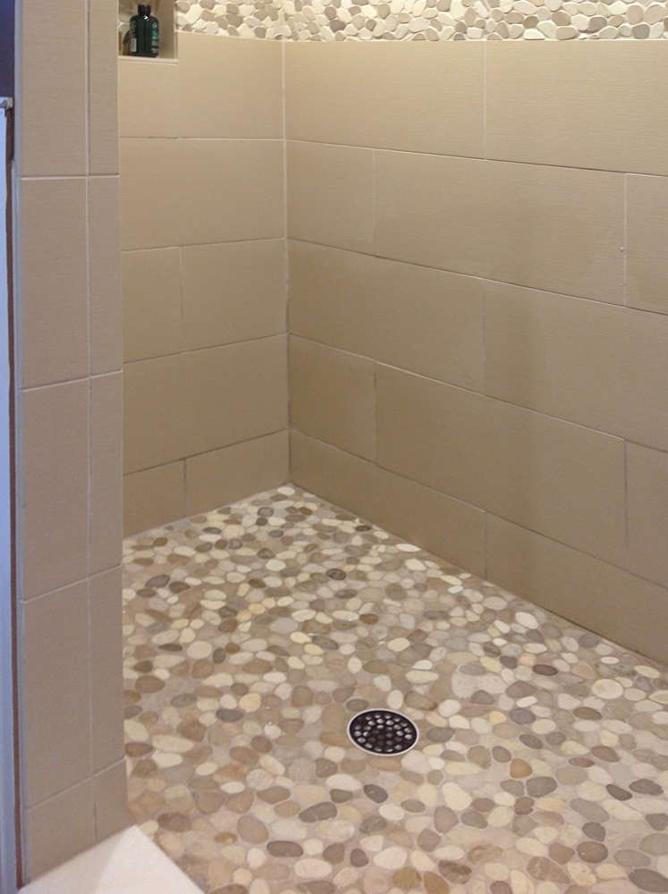 sliced-tan-and-white-pebble-tile-shower-flooring